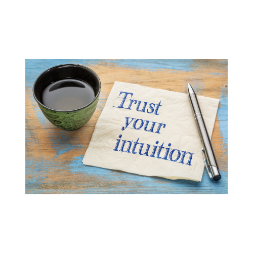 Image green mug with liquid on table next to napkin with word Trust your intuition written on it